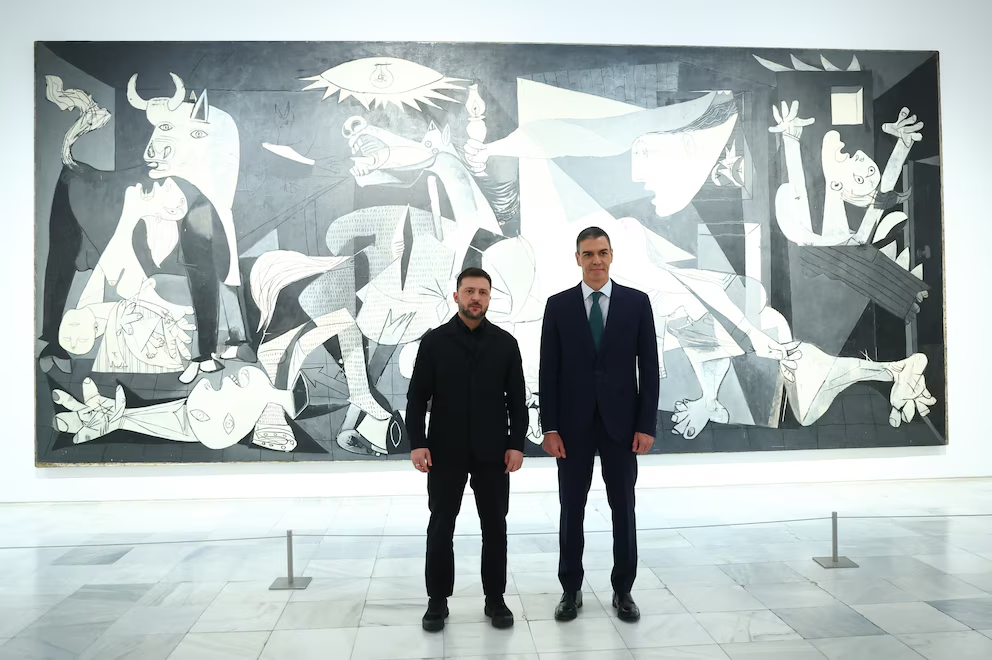 In the image, provided by the Spanish government, Ukrainian President Volodymyr Zelenskyy poses with Spanish Prime Minister Pedro Sánchez in front of Pablo Picasso's "Guernica" in Madrid on Tuesday, November 18, 2025 (Government of Spain)