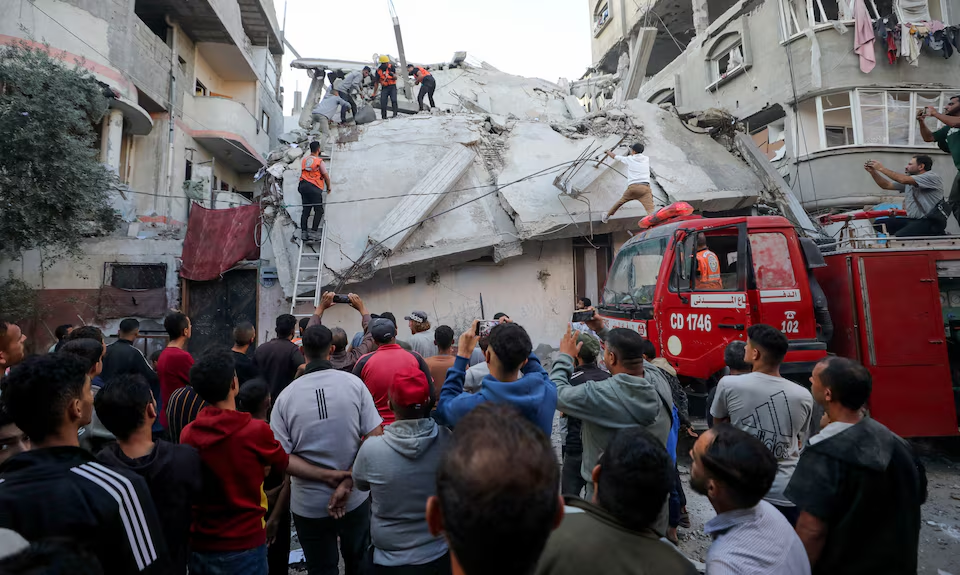 Palestinians inspect the site of an Israeli strike, in Gaza City, November 22, 2025.
